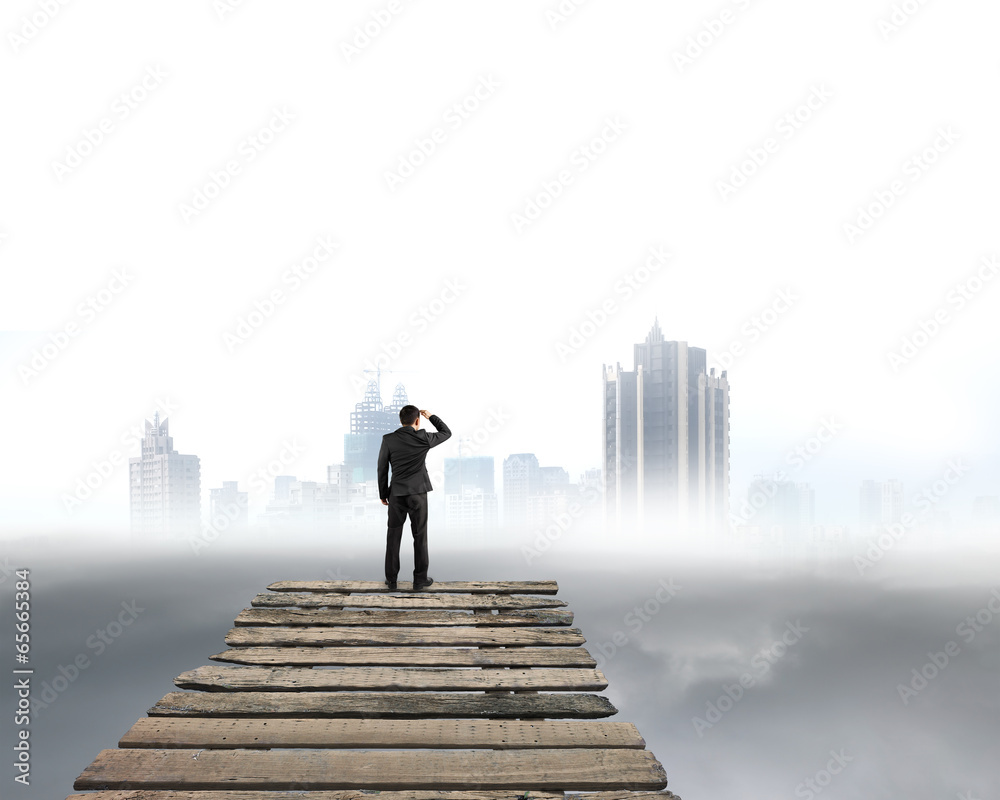 Businessman gazing at city with cloudy under