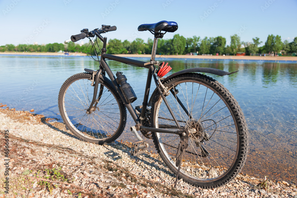 Bike on the shore of crystal clear lake