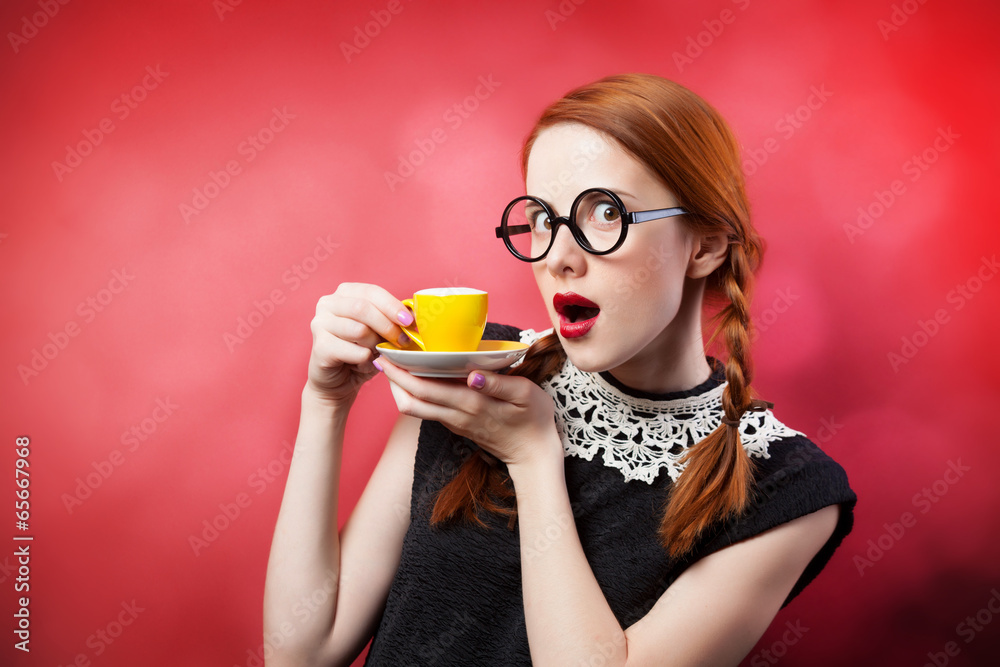 Redhead girl with cup of coffee on red background. Redhead girl with cup of coffee on red background.