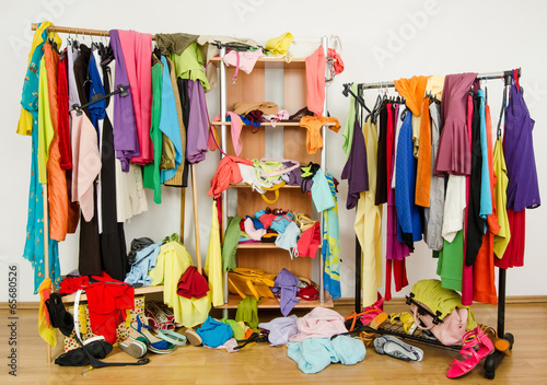 Untidy cluttered woman wardrobe with clothes and accessories. photo