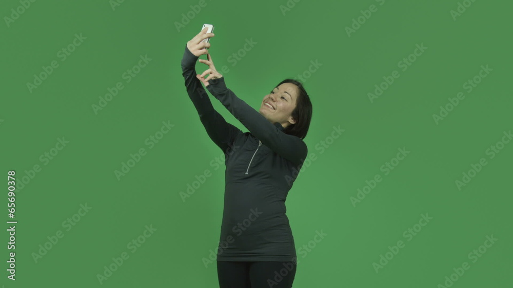 caucasian sporty girl isolated on green screen taking selfie