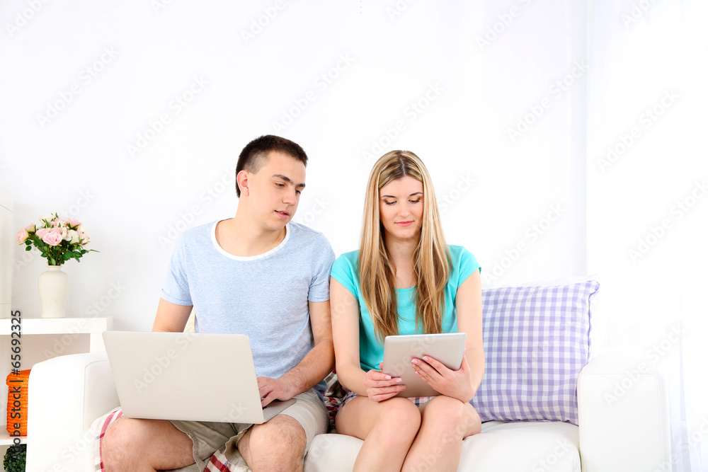 Fototapeta premium Loving couple relaxing with laptop and tablet,