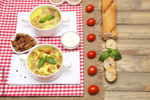 Tasty soup in saucepans on wooden table, close up