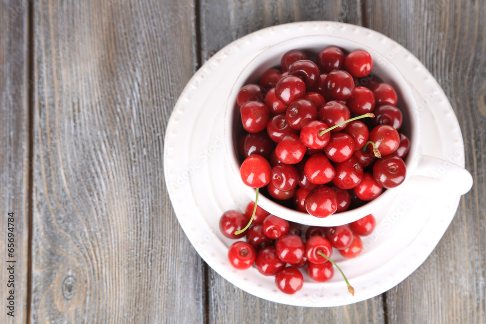 Sweet cherries in mug on wooden background Sweet cherries in mug on wooden background