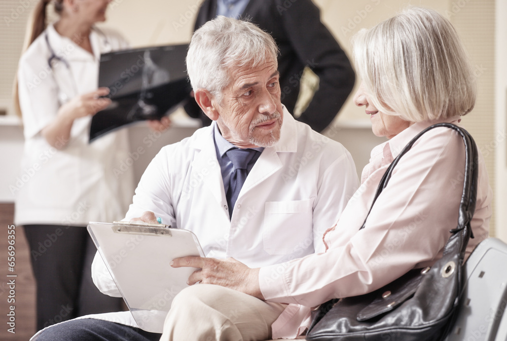 Senior male doctor showing medical results to his female woman p Senior male doctor showing medical results to his female woman p