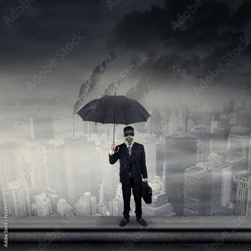 Businessman on rooftop wearing gas mask photo