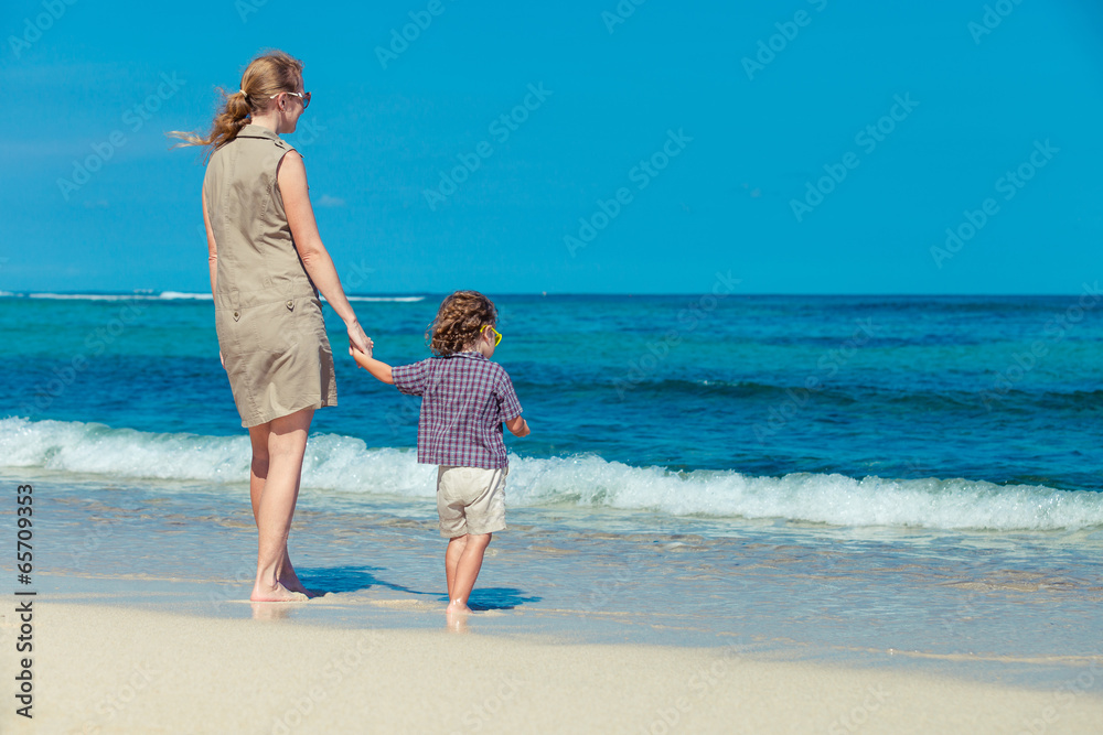 mother and  son standing on the beach in day time