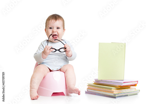 baby girl sitting on chamberpot with books
