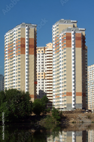 Constructed block of flats over river and clear blue sky