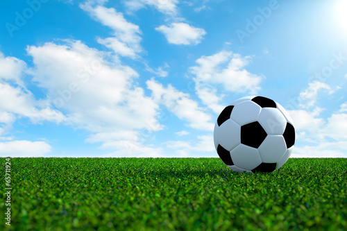 Soccer ball on field with sky background