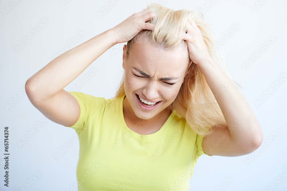 Angry woman tearing her hair in frustration Angry woman tearing her hair in frustration