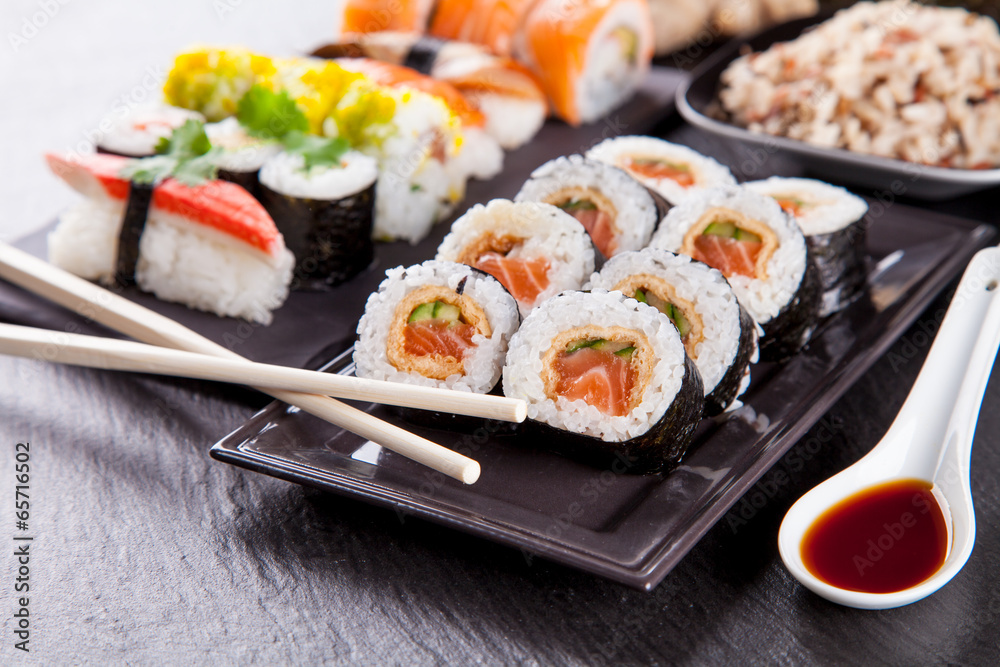 Delicious sushi pieces served on black stone Delicious sushi pieces served on black stone