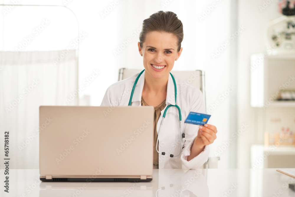 Medical doctor woman with credit card and laptop Medical doctor woman with credit card and laptop