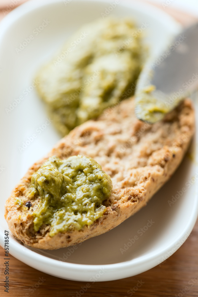 Toast with pesto sauce in bowl vertical Toast with pesto sauce in bowl vertical