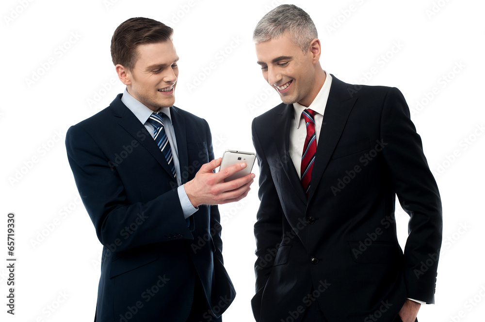 Businesspersons looking at the mobile phone Businesspersons looking at the mobile phone