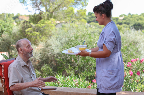carer giving senior food in residential home