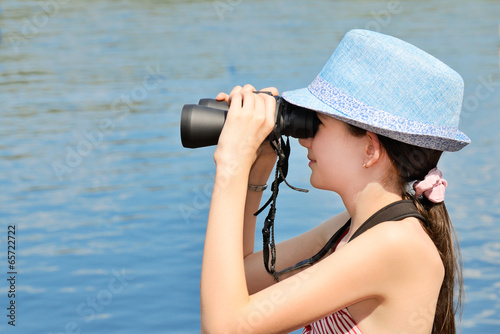 teen girl looking through binoculars side view