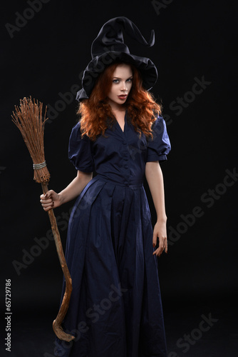 Canvas-taulu Young beautiful red-haired witch in the dark
