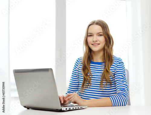 smiling teenage gitl with laptop computer at home