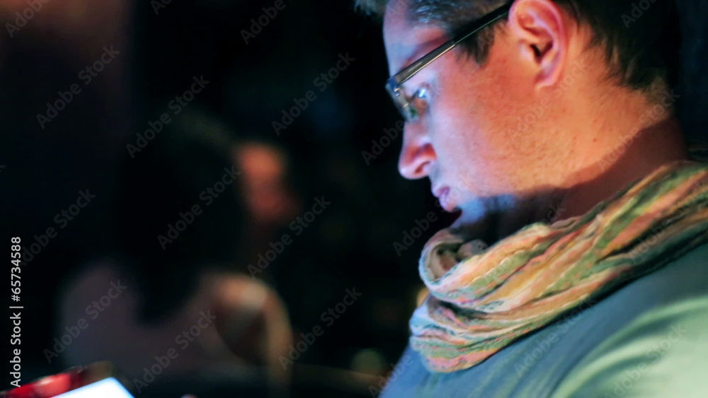 Young man with tablet sitting in a pub, steadycam shot Young man with tablet sitting in a pub, steadycam shot