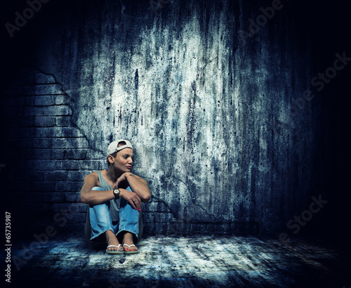 Woman sitting by the concrete wall