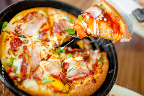 Fotografie Hot cannibal slice of pizza with extra bacon, ham and vegetables