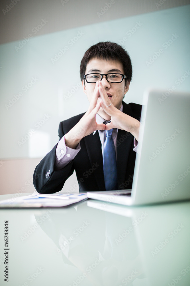 Young handsome man using laptop in his office Young handsome man using laptop in his office