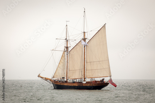 Old ship with white sales, sailing in the sea