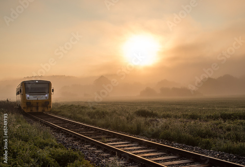 Track with the train in misty landscape at sunrise