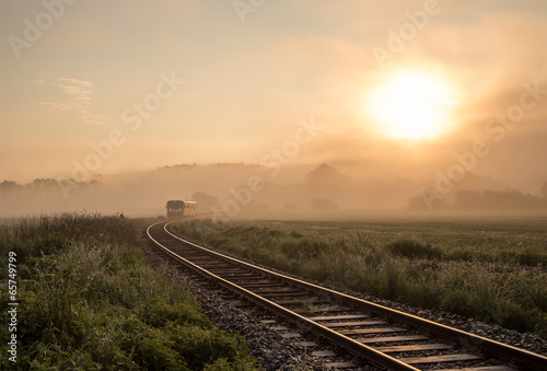 Track with the train in misty landscape at sunrise