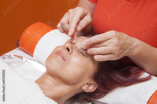 Cute woman gets professional facial massage, lymphatic drainage