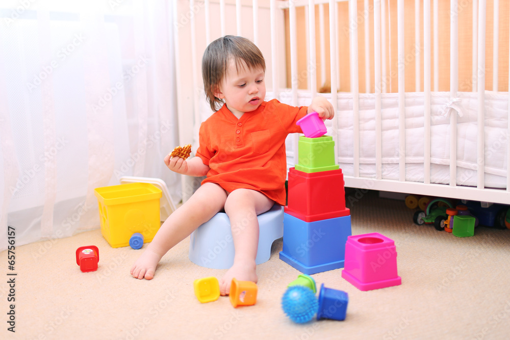 baby boy plays toys sitting on potty baby boy plays toys sitting on potty