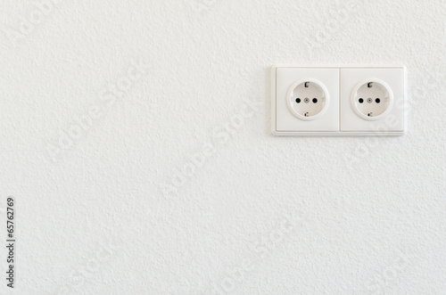 double electro socket on white wallpaper