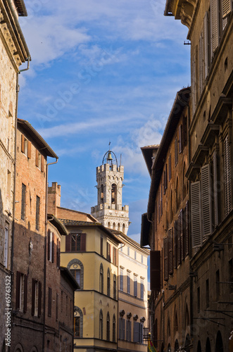 Narrow streets and old buildings in Siena  clock tower in back