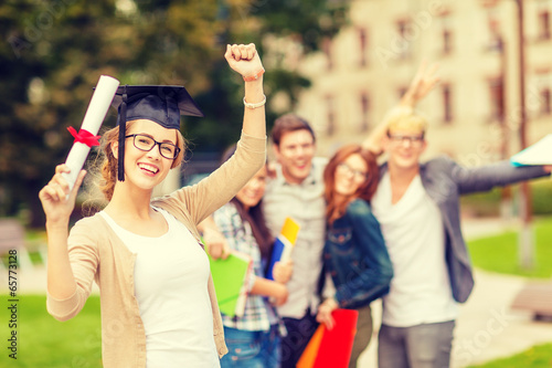 smiling teenage girl in corner-cap with diploma