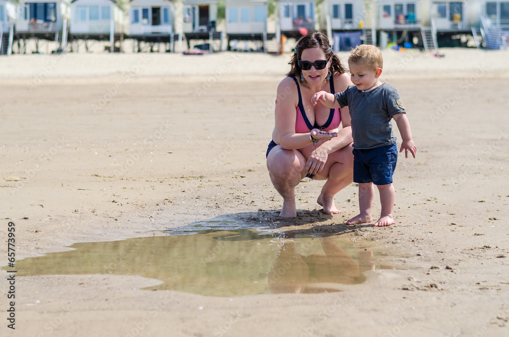 Fototapeta premium little boy splashes in a pool on the beach