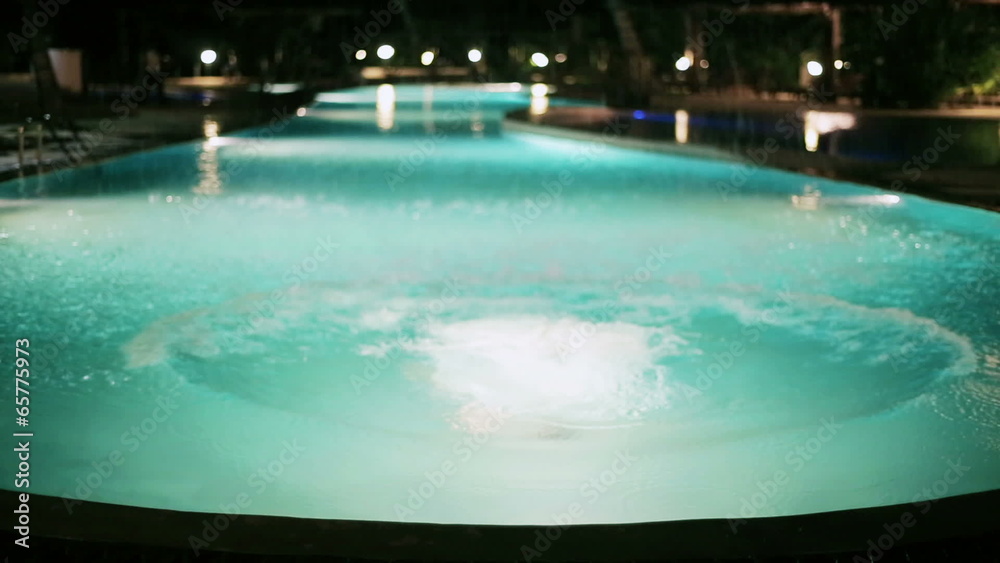 Man jumping to the pool at night Man jumping to the pool at night