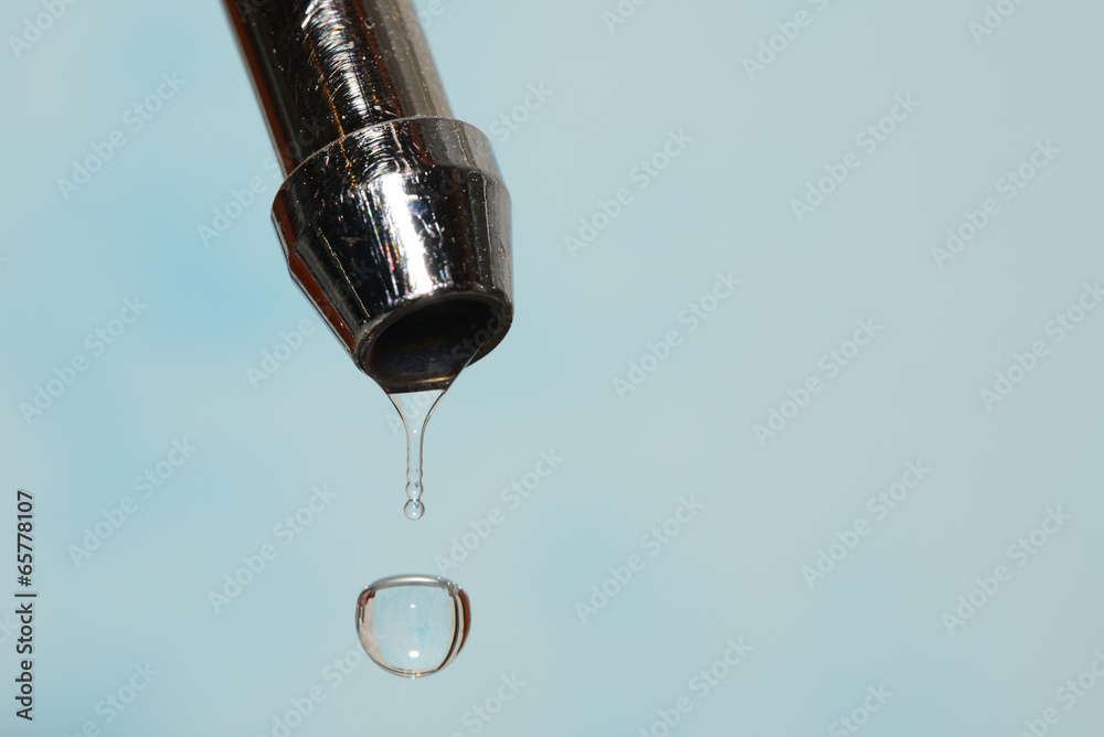 kitchen tap with water drops on a light-blue background kitchen tap with water drops on a light-blue background