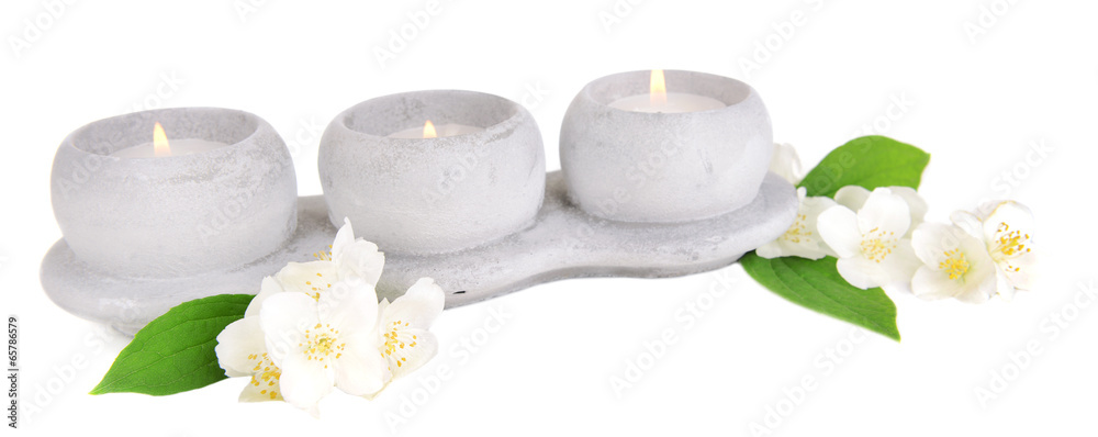 Candles with jasmine flowers isolated on white
