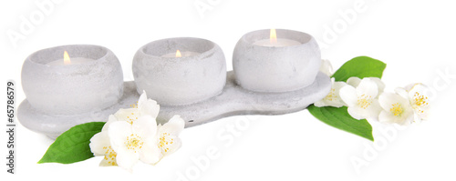 Candles with jasmine flowers isolated on white