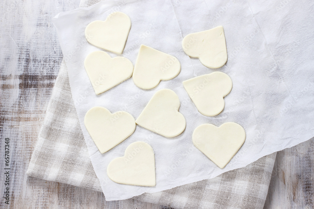 Making puff pastry cookies in heart shape filled with strawberri Making puff pastry cookies in heart shape filled with strawberri