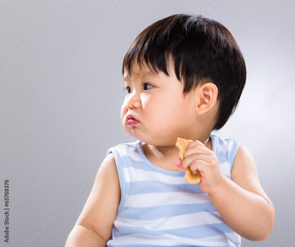 Little boy eat biscuit and look aside Little boy eat biscuit and look aside