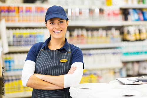 Foto young female supermarket worker with arms crossed