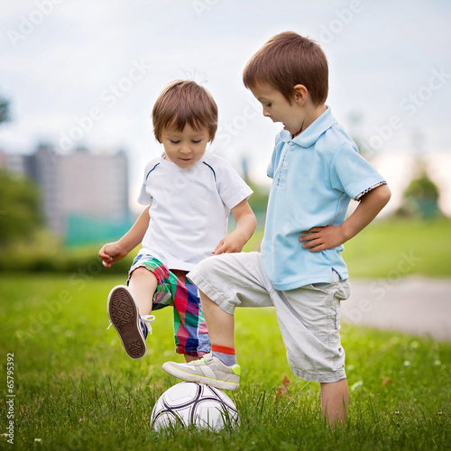 Fotografie Two cute little boys, playing football