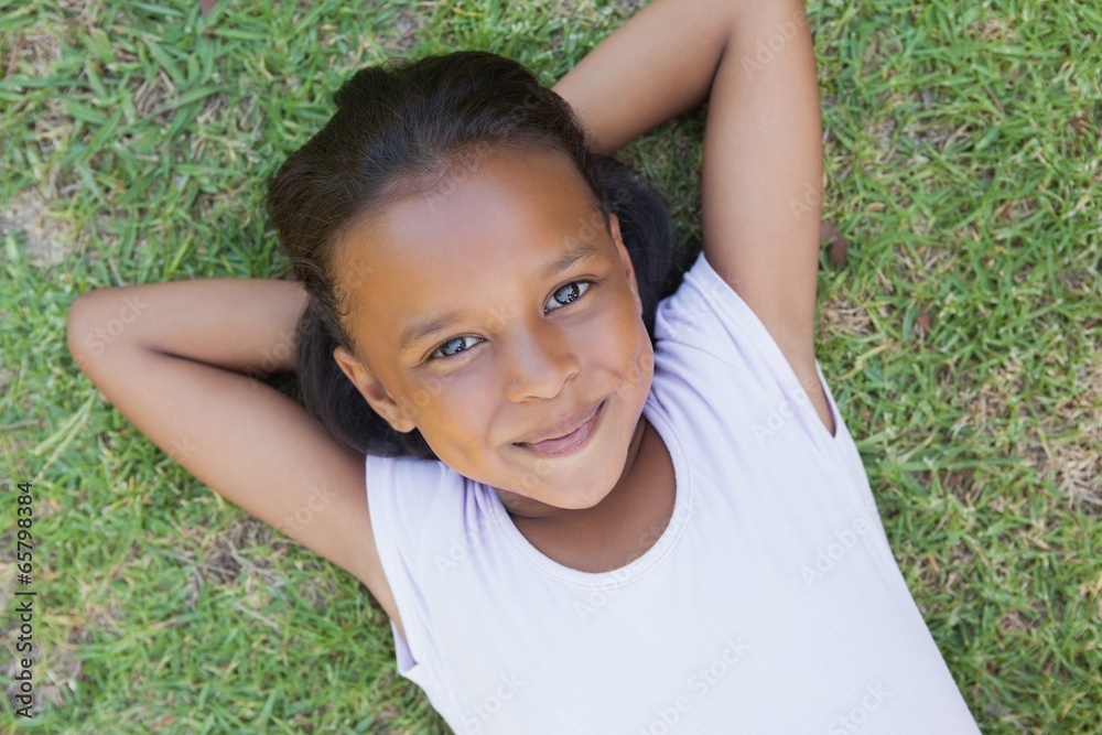 Little girl lying on the grass smiling at camera Little girl lying on the grass smiling at camera
