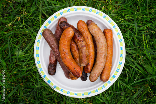 Chargrilled sausages piled on a plate.