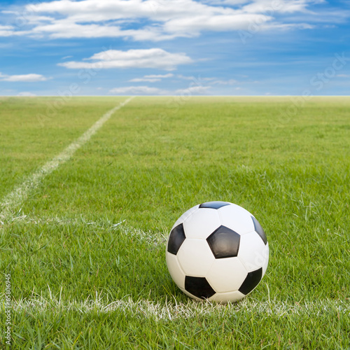 soccer ball on soccer field against blue sky