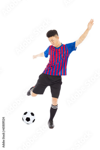 Young soccer player kicking ball