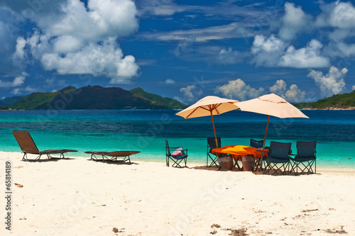 Tropical beach at Seychelles with picnic table and chairs