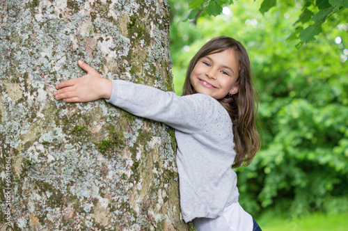 Little Girl holding big tree